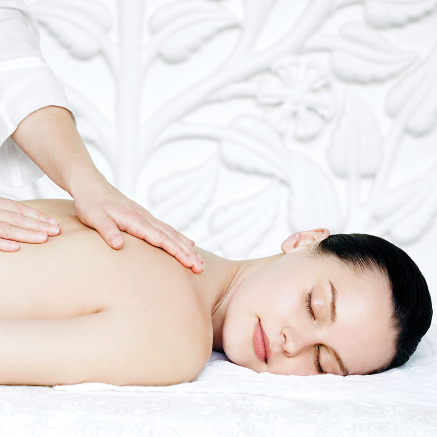 Aveda image of a lovely woman having a massage in a white room